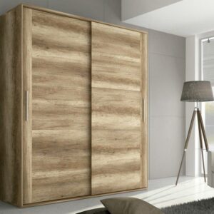 Armario con puertas correderas Chellén de melamina en color cañón instalado en un dormitorio moderno.