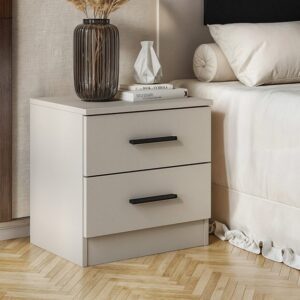 Mesita de noche Aura de estilo minimalista en color beige con dos cajones y tiradores negros, vista de frente en un dormitorio.