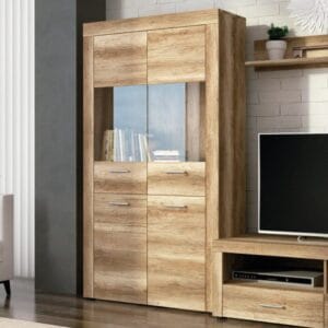 Vitrina baja Texas de estilo moderno con puerta de cristal color cañón y espacio de almacenaje, ubicada en un salón luminoso.