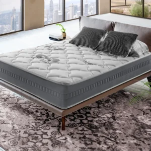 Colchón de espuma Carbono Plus sobre una base tapizada en un dormitorio, destacando su tejido acolchado y altura de 24 cm.