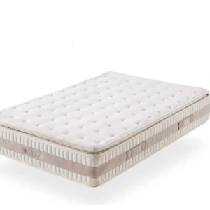 Colchón híbrido Formobel de 135x190 cm sobre una base de cama en un dormitorio luminoso, mostrando su acolchado superior.