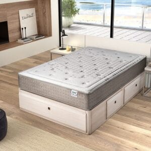 Colchón Golden de muelles ensacados y viscoelástica sobre un canapé en un dormitorio luminoso, mostrando su grosor y tejido suave.