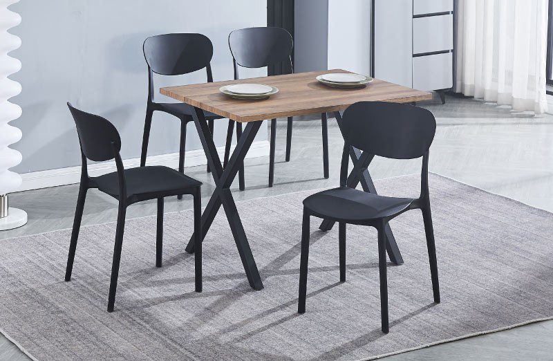 Conjunto de mesa rectangular Videl de MDF con patas negras y 5 sillas negras de polipropileno apilables, perfecto en una cocina moderna y luminosa.