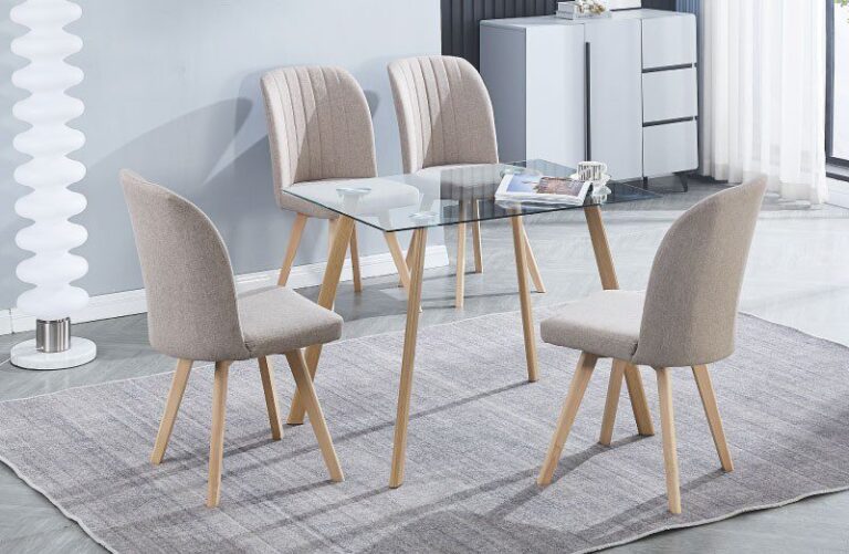 Conjunto de mesa Acnes de cristal templado rectangular y 4 sillas Lane tapizadas en tela beige y gris con patas de pino, en un comedor moderno y luminoso.