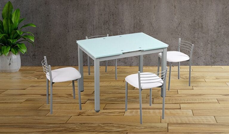 Conjunto de mesa extensible con tapa de cristal blanco y patas grises, acompañada por 4 taburetes altos tapizados en PU blanco en una cocina moderna y luminosa.