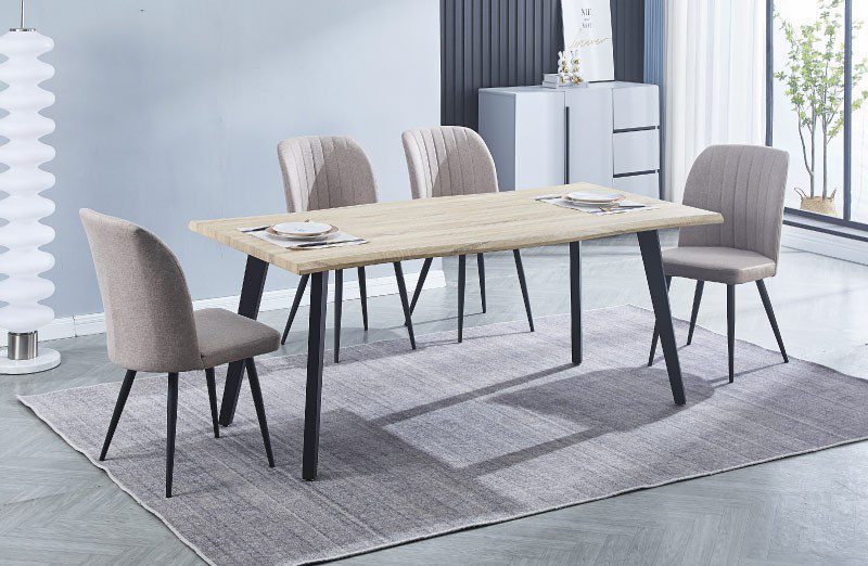 Conjunto de mesa Regatta rectangular amplia con cuatro sillas Rory tapizadas en beige y gris, en un comedor luminoso y acogedor decorado con detalles modernos.