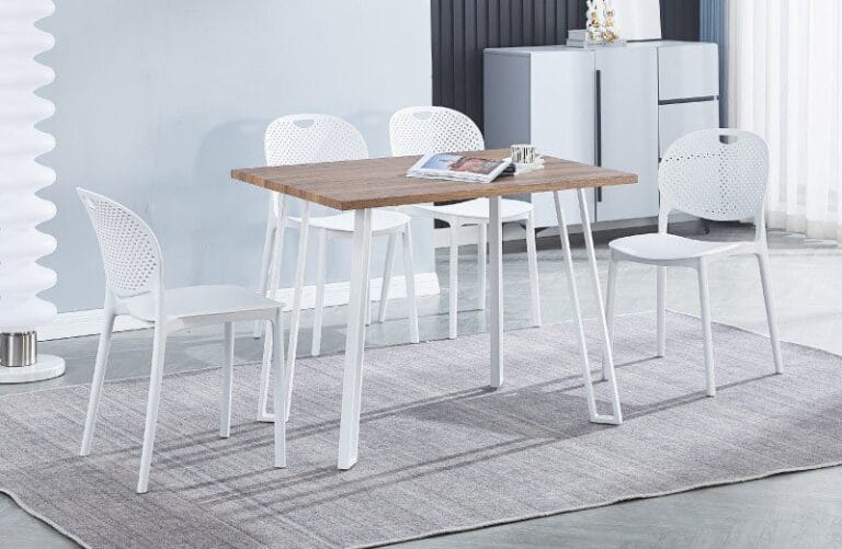 Conjunto de mesa rectangular Jansen blanca con tapa de MDF y patas metálicas, acompañado de 5 sillas apilables de polipropileno blanco en una cocina moderna y luminosa.