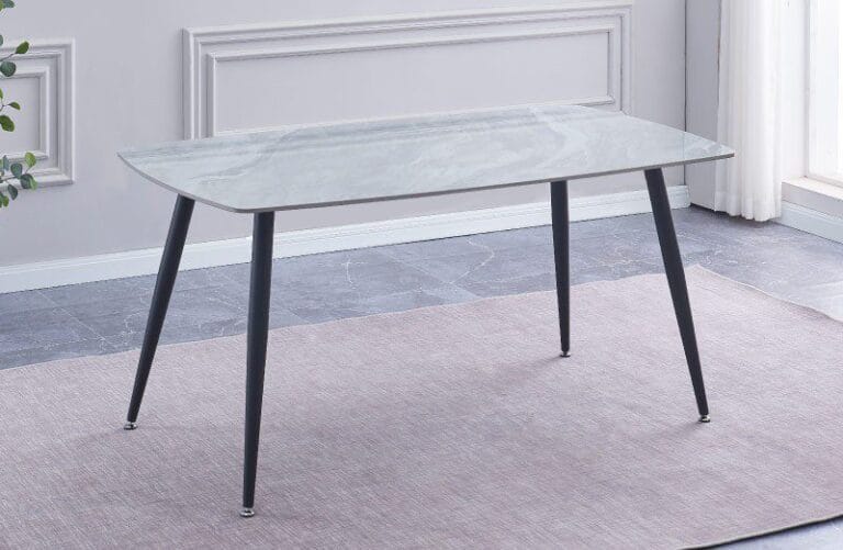 Mesa de comedor Sander con tablero de cerámica imitación mármol y patas metálicas negras, preparada para 6 personas disfrutando de una comida en un comedor moderno y elegante.