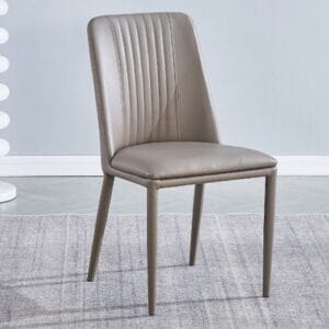 Pack de 2 sillas de comedor Rowena tapizadas en pu color latte o tórtora, con patas metálicas pintadas, ambientadas junto a una mesa moderna.
