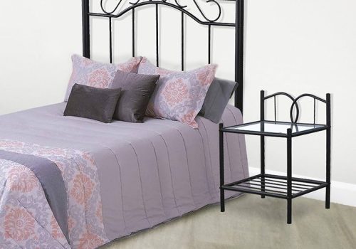 Elegante cabecero de forja Deirdre en color negro mate decorando una cama en un dormitorio moderno.