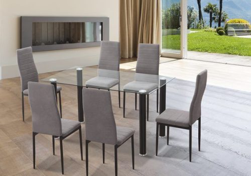 Conjunto de comedor Yuri con mesa rectangular de cristal transparente y patas de acero negro junto a seis sillas tapizadas en microfibra gris marengo en un comedor moderno y luminoso.