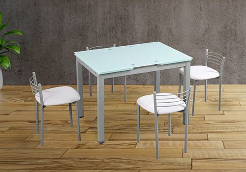 Conjunto de mesa extensible con tapa de cristal blanco y patas grises, acompañada por 4 taburetes altos tapizados en PU blanco en una cocina moderna y luminosa.