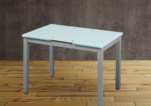 Mesa de cocina extensible Modelo 70 de cristal blanco con patas metálicas en una cocina moderna y luminosa, ideal para espacios pequeños y ampliada para una comida familiar.