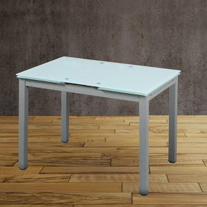 Mesa de cocina extensible Modelo 70 de cristal blanco con patas metálicas en una cocina moderna y luminosa, ideal para espacios pequeños y ampliada para una comida familiar.