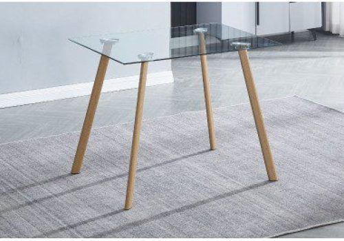 Mesa de comedor de cristal templado modelo Acnes, ideal para 4 personas, situada en un comedor moderno y compacto, rodeada de sillas blancas con patas metálicas y luz natural.