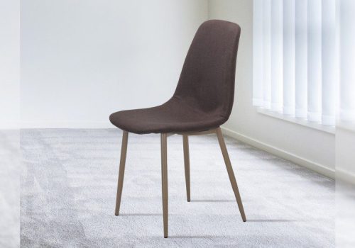 Pack de 4 sillas de comedor Cody tapizadas en tela marrón, con patas metálicas efecto madera, alrededor de una mesa moderna en el salón.