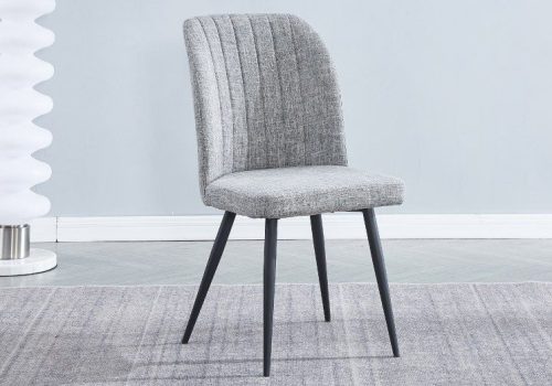Pack de 4 sillas de comedor Rory, tapizadas en tela beige o gris con patas metálicas negras, aportando diseño moderno a cualquier hogar.