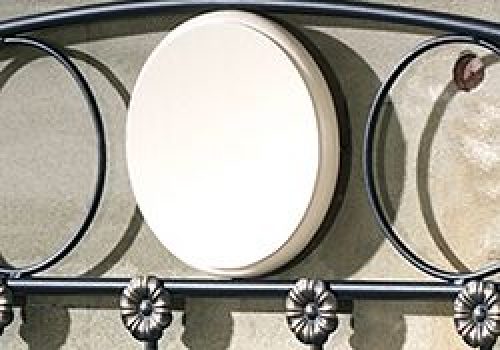 Un panel decorativo para cabecero Munich en color blanco, instalado sobre una cama de estilo moderno.
